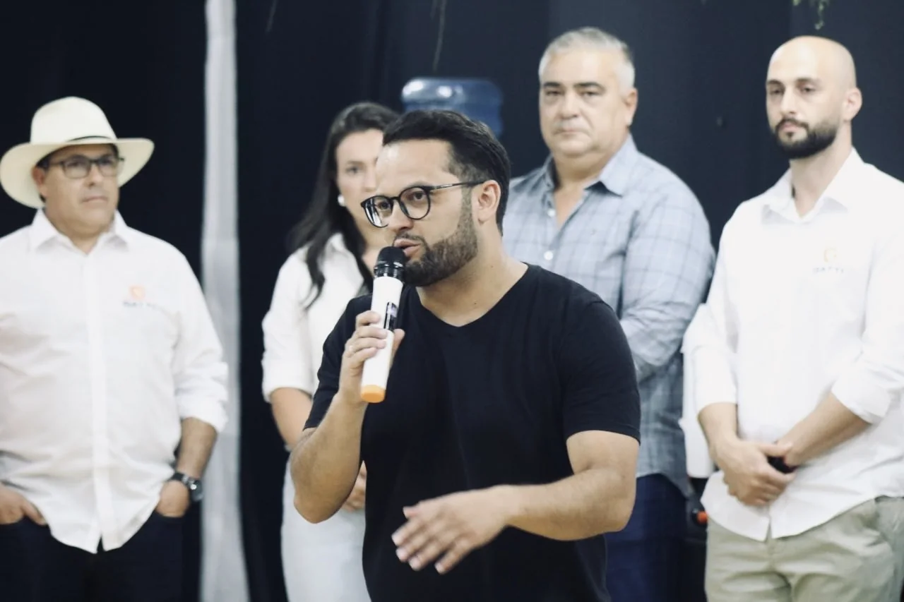 Bainho falando ao microfone em um encontro com moradores